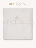 Drap de lit à volants blanc cassé.